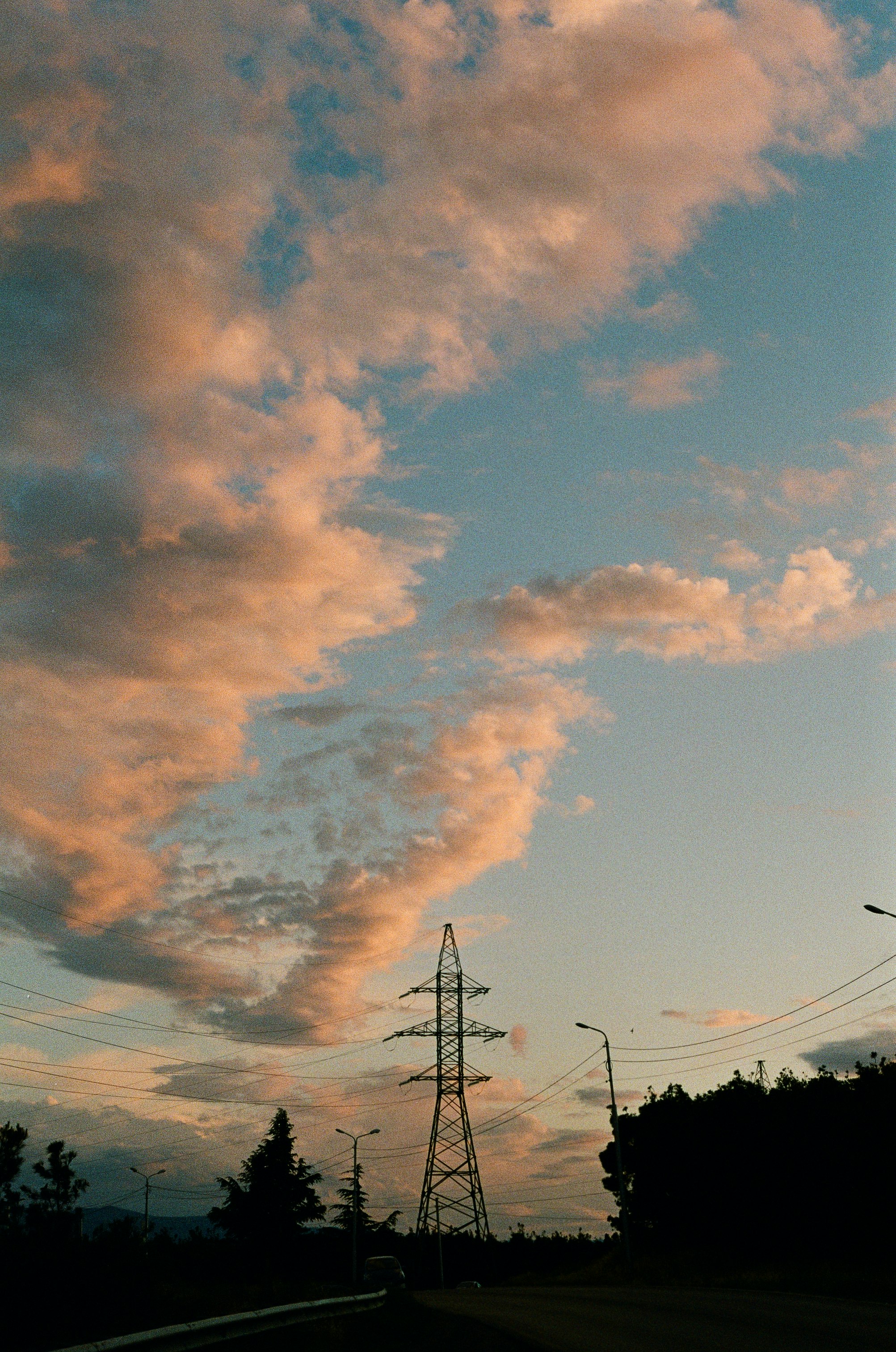 black electric post under blue sky and white clouds during daytime